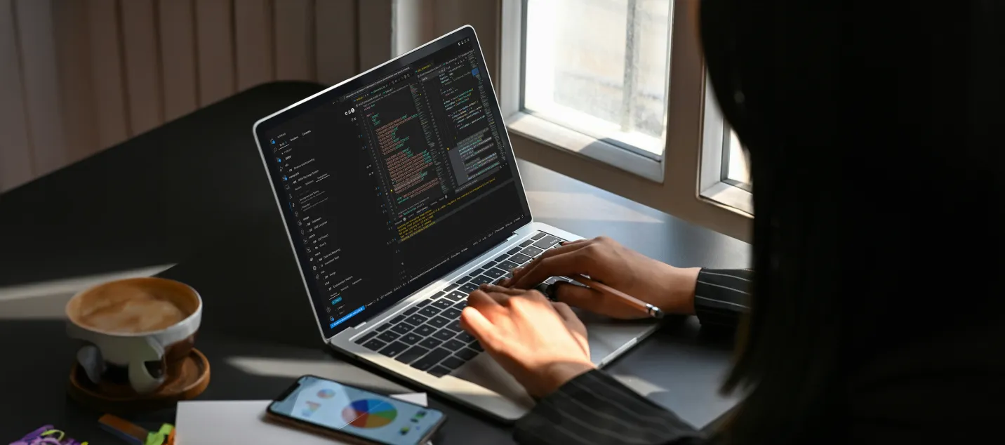 Image of a user typing on a laptop at her desk.